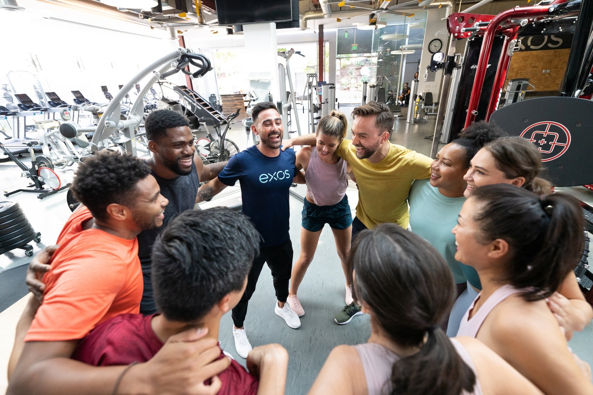 An Exos coach huddles with client members on launch day.