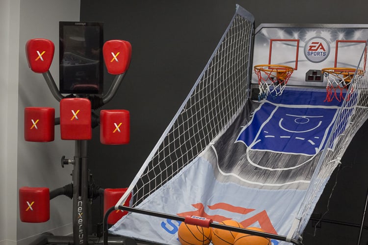 Indoor basketball arcade game and reflex training machine in a fitness or recreation area.