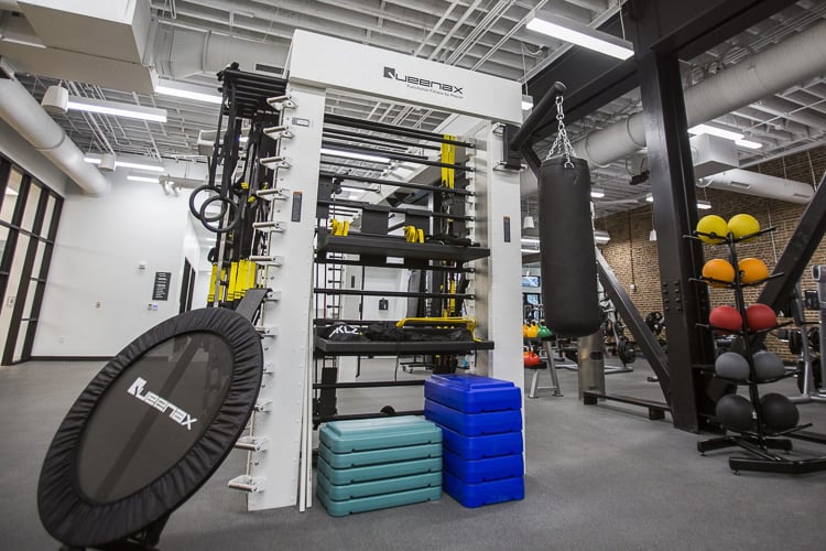 Functional training area with boxing bag, resistance equipment, medicine balls, and a rebounder.