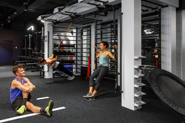 Employees using modular training equipment in a high-performance fitness space designed for functional movement.