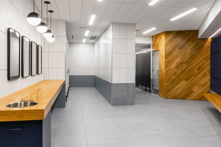 Modern locker room featuring clean lines, warm wood accents, and amenities designed to elevate the employee experience.