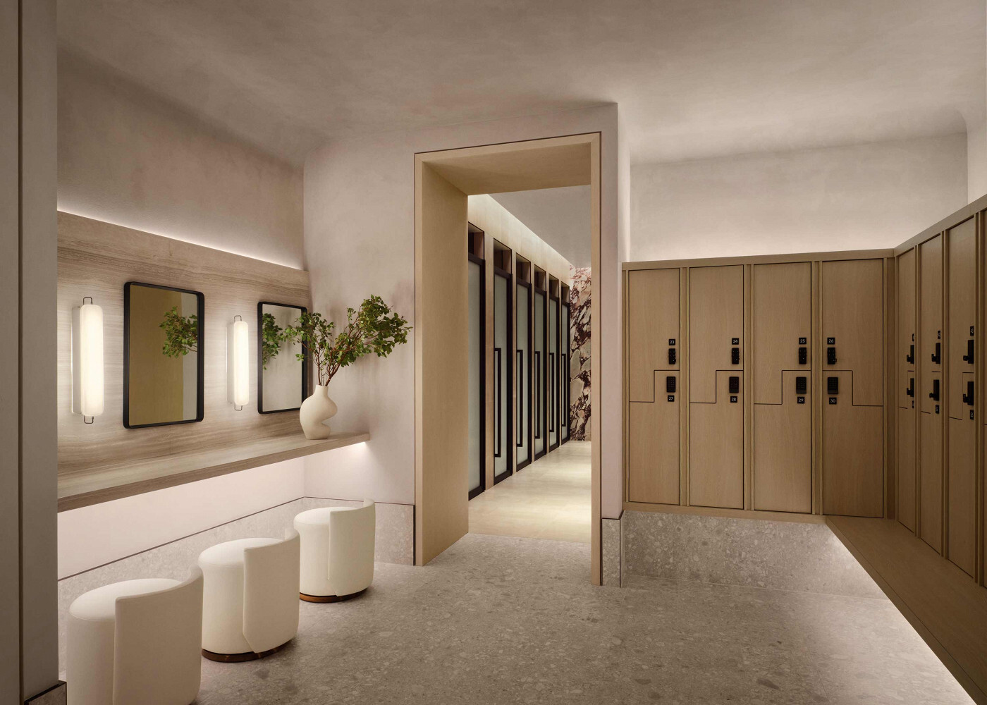 Modern locker room with light wood lockers, vanity seating, and soft ambient lighting.