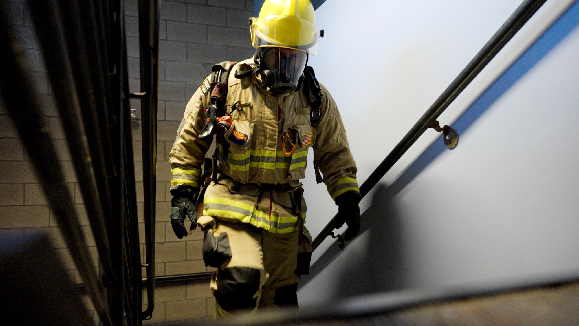 A firefighter walks up a staircase