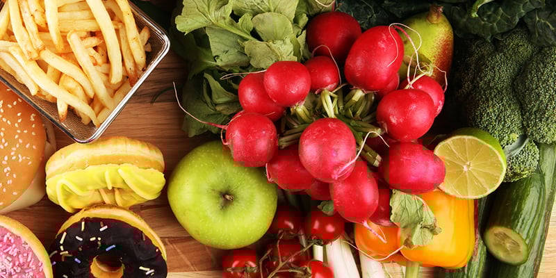 Split view of colorful vegetables and indulgent foods representing the 80/20 Method — a balanced nutrition approach.