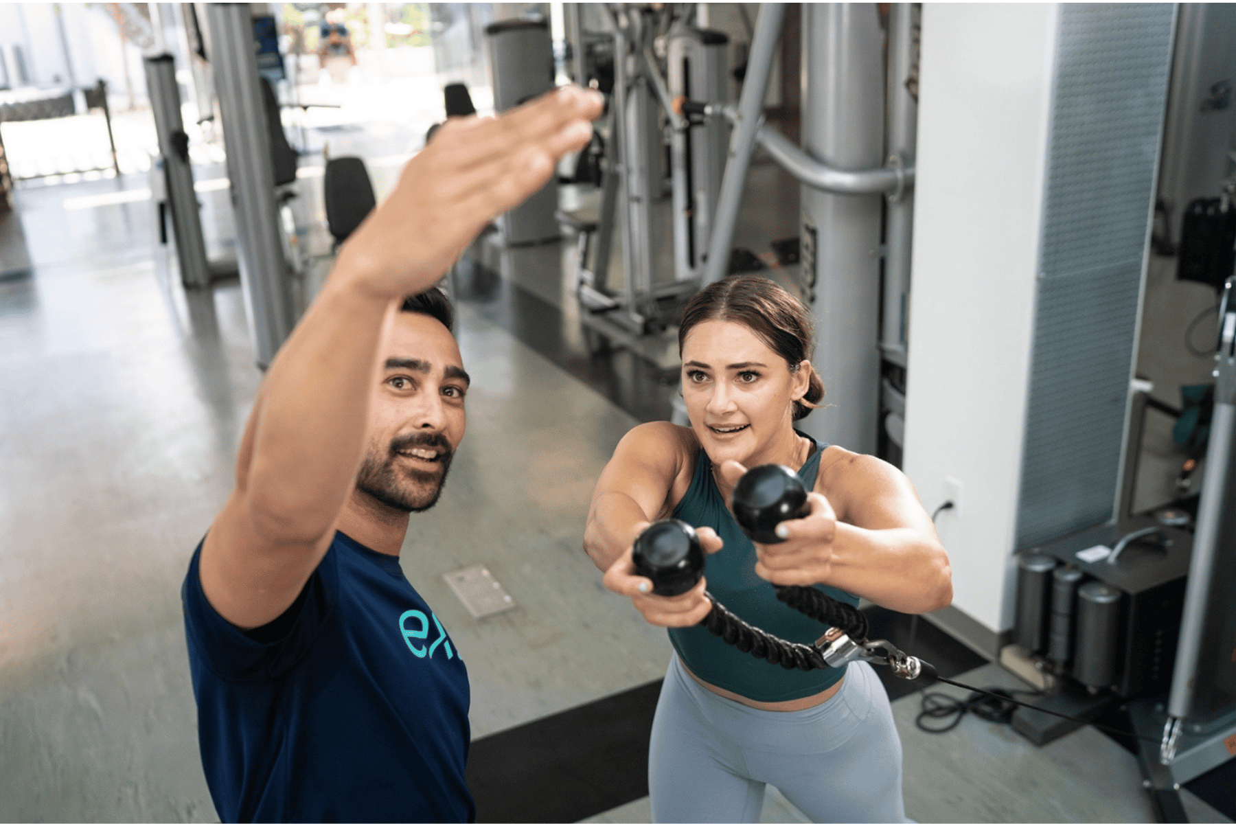 Exos coach supporting employees in a corporate fitness center