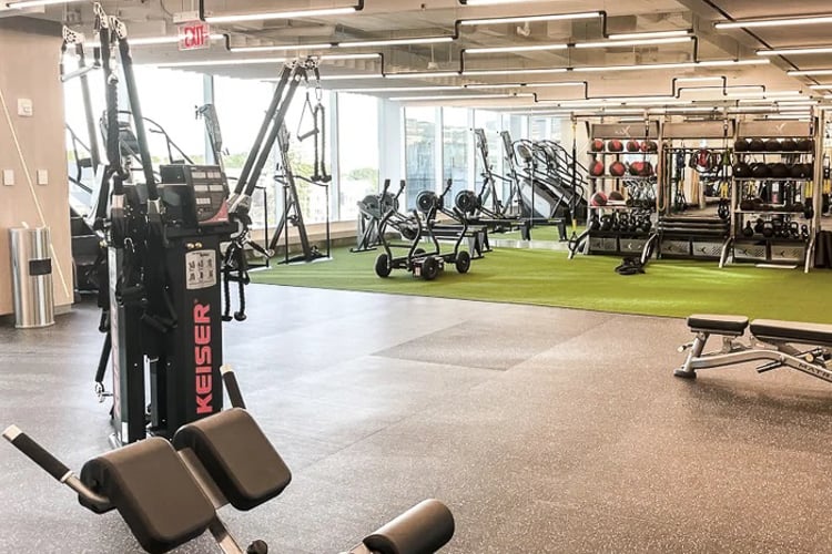 Spacious fitness center with turf area, resistance machines, and neatly organized training equipment.