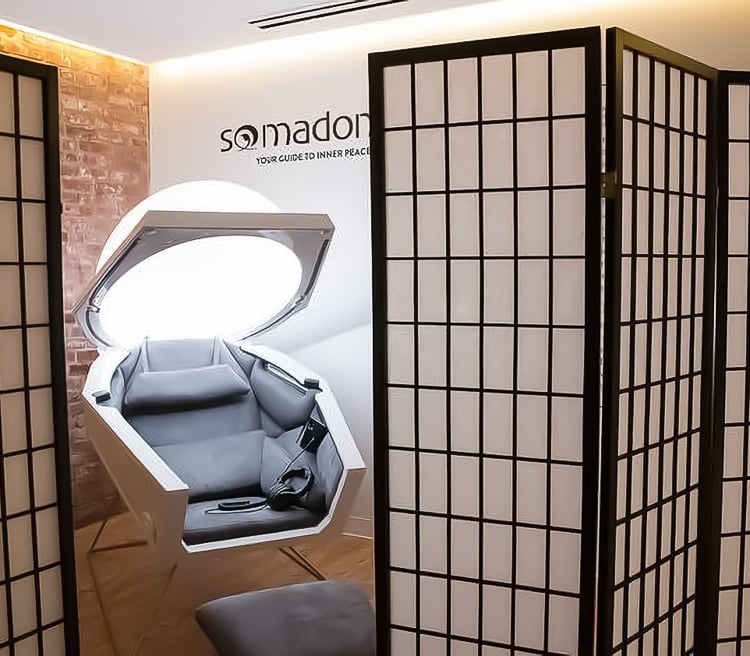 Somadome meditation pod in a private wellness space with soft lighting and privacy screens.