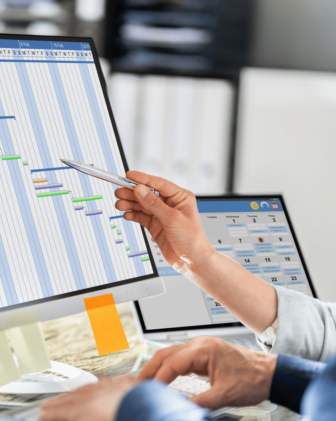 An Exos project manager points to scoped timelines on a computer monitor.