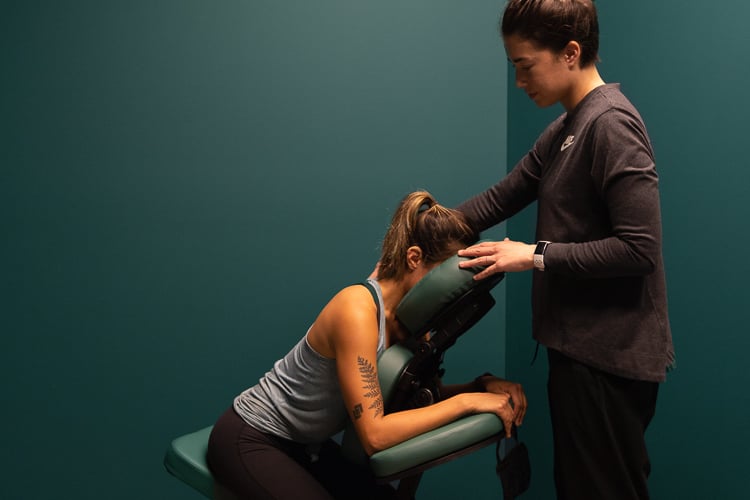 Recovery session in a private wellness room, with one-on-one chair massage supporting employee recovery.