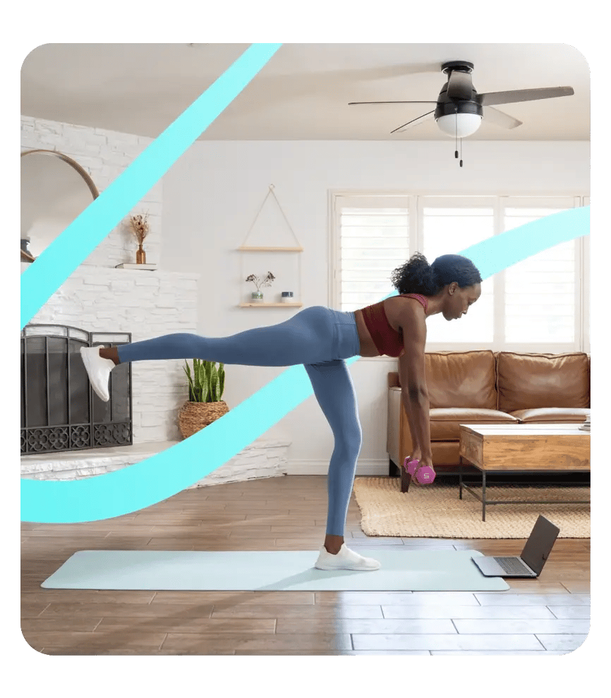 Employee engaging in an Exos virtual workout from home, guided by coaching on a laptop.
