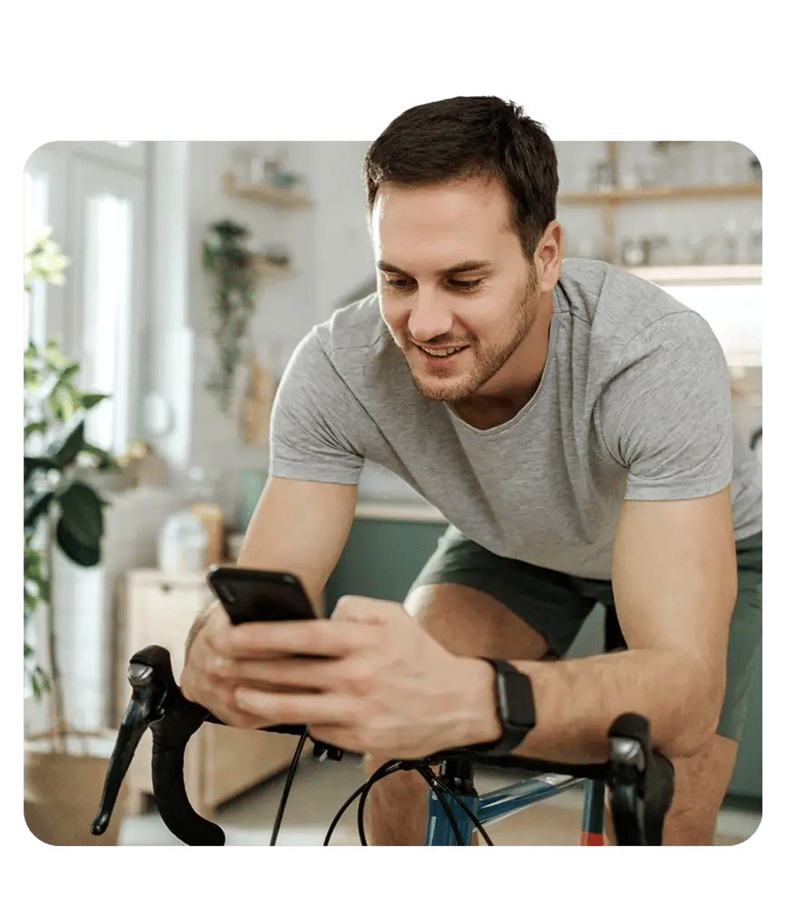 A man follows a guided workout on a stationary bike.
