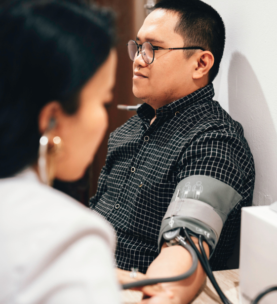 Employee receives a blood pressure check during workplace health screening, highlighting early risk detection and care.